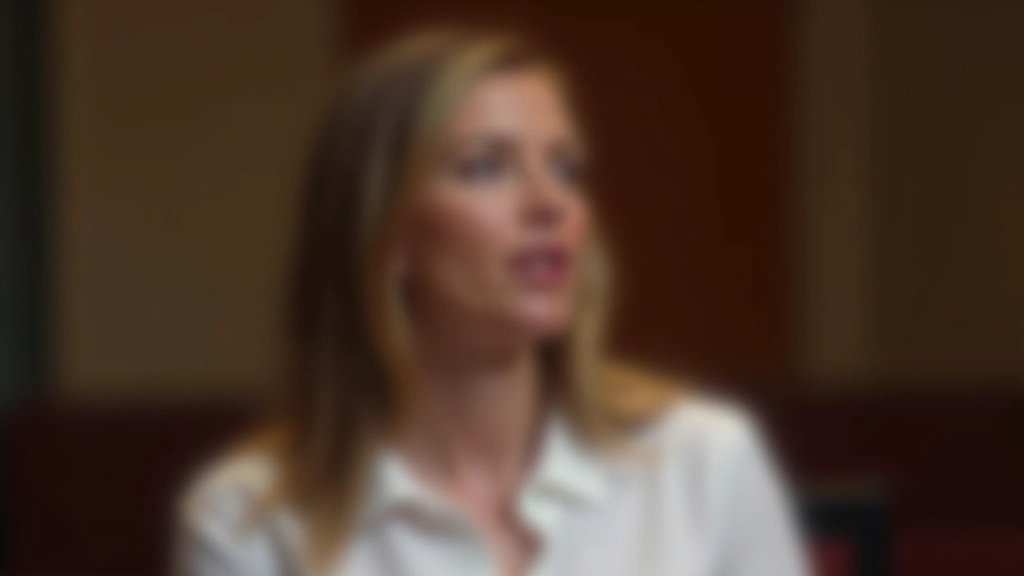 Female speaker in front of audience demonstrating clear articulation and proper mouth positioning for vocal projection
